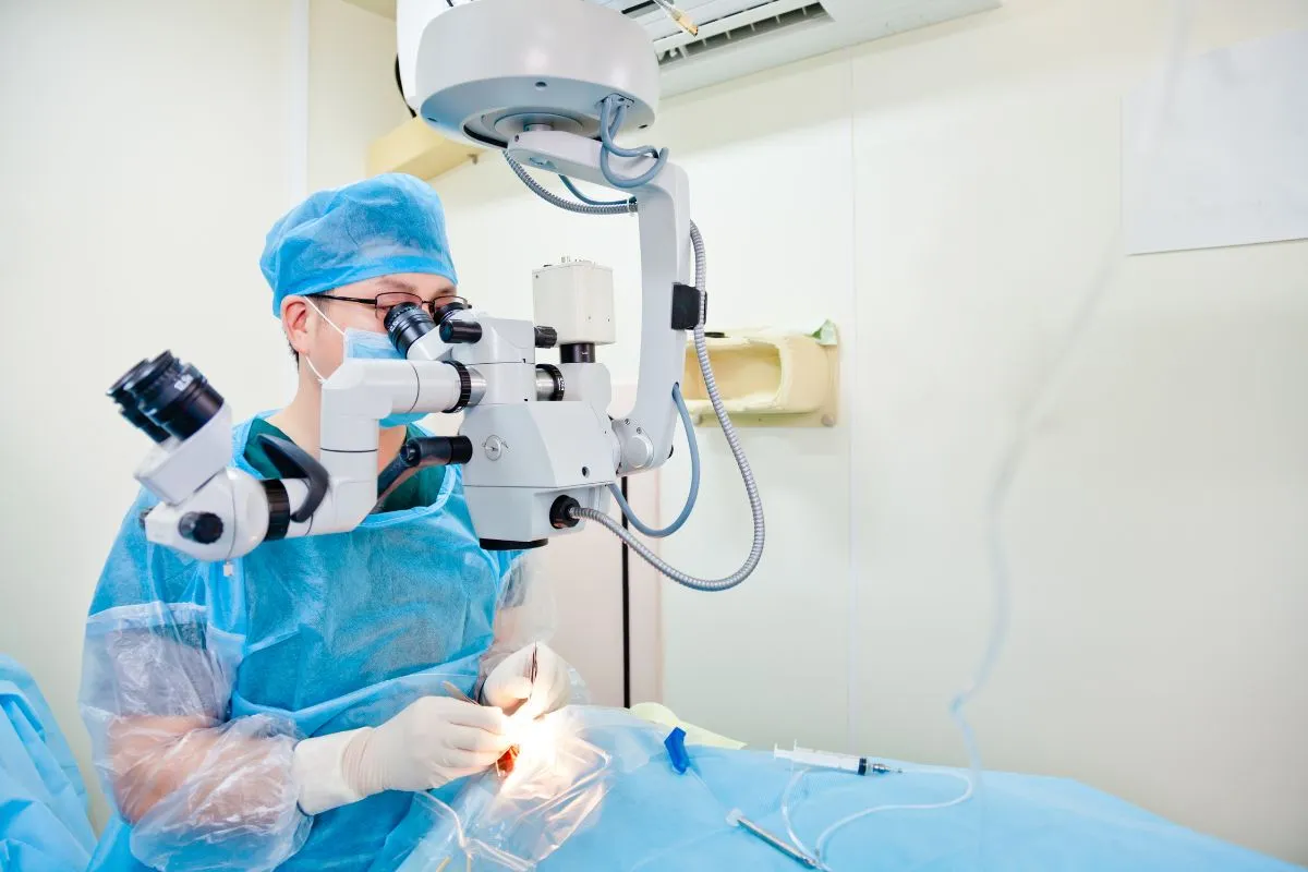 Ophthalmic surgeon performing cataract surgery under a surgical microscope